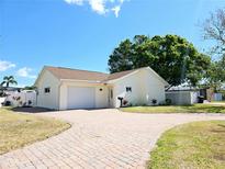 Charming single-story home with a brick driveway and well-manicured lawn at 8719 Sunlit Cove Ne Dr, St Petersburg, FL 33702
