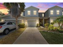 Charming townhome exterior with a one-car garage, inviting landscape, and pleasant facade at 10687 Lake Montauk Dr, Riverview, FL 33578