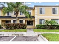 Inviting exterior view of a two-story townhouse with a well-maintained lawn and mature landscaping at 10807 Keys Gate Dr, Riverview, FL 33579
