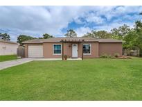 Charming single-story home with a well-maintained lawn, inviting entryway, and attached one car garage at 11396 Terrell Rd, Spring Hill, FL 34608