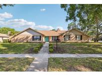 Charming single-story home featuring a well-manicured lawn, inviting entryway, and appealing brick facade at 170 Foxfire Ln, Oldsmar, FL 34677
