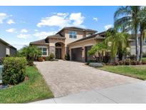 Beautiful two-story home featuring a paved driveway, two-car garage, stone accents, and mature landscaping at 31382 Chesapeake Bay Dr, Wesley Chapel, FL 33543