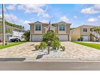 Beautiful two-story home with a charming brick driveway and manicured landscaping at 314 Crosswinds Dr, Palm Harbor, FL 34683