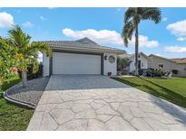 Charming single-story home with a two-car garage, a well-manicured lawn, and tropical landscaping at 3819 Barnegat Dr, Punta Gorda, FL 33950