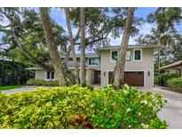 Elegant two-story home featuring lush landscaping, a two-car garage, and a well-maintained front yard at 5018 S The Riviera St, Tampa, FL 33609