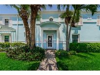 Charming light blue home featuring a white door, lush landscaping, and a welcoming brick walkway at 5094 Starfish Se Dr # E, St Petersburg, FL 33705
