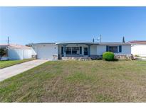 Charming single-story home with well-manicured lawn, stone accents, and a classic white exterior at 5203 Overton Dr, New Port Richey, FL 34652