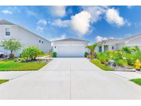 Charming one-story home with a well-manicured lawn and a spacious driveway under a bright blue, partly cloudy sky at 6333 Milestone Loop, Palmetto, FL 34221