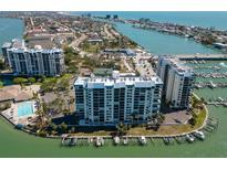An aerial view of a waterfront condominium complex with a pool and marina, nestled in a beautiful coastal community at 9495 Blind Pass Rd # 308, St Pete Beach, FL 33706