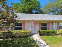 Charming single-story home with pink shutters, lush landscaping, and a welcoming front entrance at 1535 Nursery Rd # 111, Clearwater, FL 33756