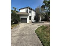 Charming two-story home with a well-maintained lawn, driveway, and an attached garage, perfect for suburban living at 3014 S West Shore Blvd, Tampa, FL 33629