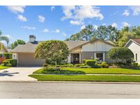 Charming single-story home with well-manicured lawn, mature landscaping, and a two-car garage at 3579 Landmark Trl, Palm Harbor, FL 34684