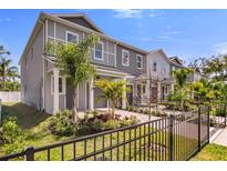 Charming townhomes featuring manicured lawns, small palm trees and decorative front fences at 5530 N 9Th St # 1, Tampa, FL 33604