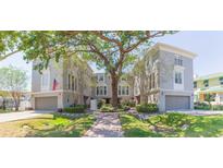 Beautiful townhouse exterior featuring a lush green lawn and manicured landscaping at 111 S Delaware Ave # 1, Tampa, FL 33606