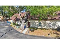 Cozy single story home with a brown roof, and a sidewalk leading to the front door, partially shaded by a mature tree at 12425 Touchton Dr # 77, Tampa, FL 33617