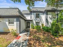 Charming townhome featuring a gray roof, neutral paint, and well-maintained landscaping at 1303 N Mcmullen Booth Rd # 1303, Clearwater, FL 33759