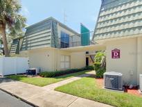 Inviting exterior view of condo building with manicured landscaping, sidewalk and covered entry at 1799 N Highland Ave # 32, Clearwater, FL 33755