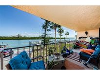 Cozy balcony featuring views of the water and docks, perfect for relaxing and enjoying the waterfront scenery at 18201 Gulf Blvd # 201, Redington Shores, FL 33708