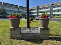 South Seas building sign with red potted plants and well-manicured lawn at 2255 Philippine Dr # 21, Clearwater, FL 33763