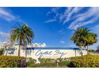 Crystal Bay at Feather Sound signage surrounded by lush tropical landscaping under a blue sky at 2323 Feather Sound Dr # F101, Clearwater, FL 33762