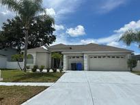 Charming single-story home with a three-car garage, well-manicured lawn, and mature palm trees at 2816 Pankaw Ln, Valrico, FL 33596