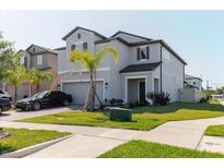 Charming two-story home featuring a well-maintained lawn and a paved driveway at 3047 Adams Cross Dr, Zephyrhills, FL 33540