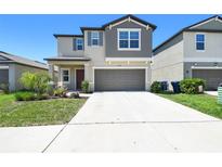 Charming two-story home showcasing a well-manicured lawn and a spacious driveway at 31440 Barrel Wave Way, Wesley Chapel, FL 33545