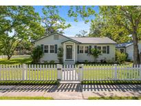 Charming single-story home with a white picket fence and a well-manicured lawn at 317 N Washington Ave, Clearwater, FL 33755
