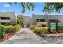 Condo complex with lush landscaping and well maintained walkway leading to the building entrance at 36750 Us 19 N # 24-104, Palm Harbor, FL 34684