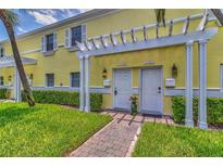 Charming townhouse entrance featuring well-maintained landscaping and a pergola over the doorways at 3751 Pompano Se Dr # 3751, St Petersburg, FL 33705