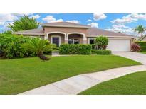 Charming single-story home with lush landscaping, a well-manicured lawn, and a welcoming front entrance at 3913 Little Egret Ct, Lutz, FL 33558
