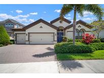 Charming home featuring a three car garage, lush landscaping, and an inviting blue front door at 6307 Salt Creek Ave, Apollo Beach, FL 33572