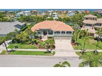 Stunning waterfront home featuring a terracotta roof, lush landscaping, and an inviting two-story facade at 6461 Rubia Cir, Apollo Beach, FL 33572
