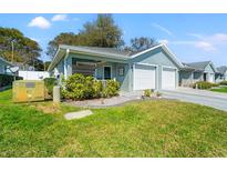 Charming single-story home with a well-maintained lawn and attached two-car garage at 6745 Basswood Cir, Zephyrhills, FL 33542
