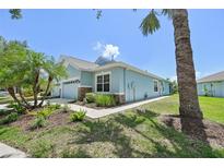 Charming single-story home featuring stone accents, lush landscaping, and a well-manicured lawn on a sunny day at 7413 Surrey Wood Ln, Apollo Beach, FL 33572
