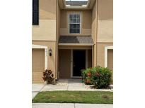 Charming townhome with neutral paint, attached garage, and inviting front entrance at 8013 Savannah Sunset Ln, Tampa, FL 33615
