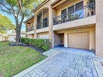 Two-story home with balconies, a garage, a paved driveway, and lush landscaping in a well-maintained community at 810 Island Walk Dr # 810, Tampa, FL 33602