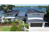 Beautiful modern home with lush landscaping and a view of the bay, showcasing its attractive curb appeal at 915 Bayshore Dr, Tarpon Springs, FL 34689