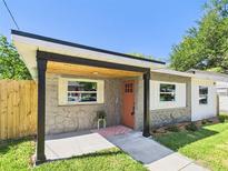 Charming single-story home showcasing a stone facade and a covered front entry with wood accents at 1221 E Emma St, Tampa, FL 33603