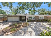 Charming single-story home with stone facade, two-car garage, and well-maintained front yard at 1557 Robinson N Dr, St Petersburg, FL 33710
