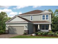 Charming two-story home featuring a covered porch, a two-car garage and manicured landscaping at 1726 Trailhead Ln, Zephyrhills, FL 33541