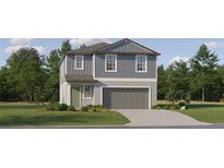 Charming two-story home with blue siding, attached garage, and well-manicured lawn at 17611 Happytrails St, Land O Lakes, FL 34638