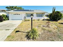 Charming single-story home featuring a well-maintained front yard and a one car garage at 203 Rickenbacker Dr, Sun City Center, FL 33573