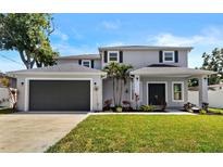 Charming two-story home featuring a manicured lawn, a two-car garage, and tasteful landscaping at 3612 W Pearl Ave, Tampa, FL 33611