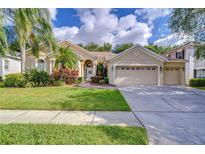 Charming single-story home boasts a lush front lawn, landscaping, and a two-car garage at 5114 Whispering Leaf Trl, Valrico, FL 33596