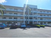 Charming condo building featuring multiple floors with balconies and a well-maintained parking area at 5970 80Th N St # 312, St Petersburg, FL 33709