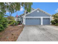 Charming home featuring a spacious three-car garage, well-maintained landscaping, and a welcoming front facade at 8704 Tarrington Pl, Tampa, FL 33635
