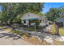 Charming single-story home with a fenced yard and mature trees offering shade at 1205 E Emma St, Tampa, FL 33603