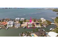Waterfront property showcasing a home with a private pool and dock, set amidst a picturesque coastal landscape at 19 N Pine Cir, Belleair, FL 33756