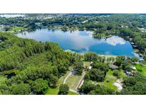Breathtaking aerial view of a beautiful lake surrounded by lush greenery and scattered homes at 22129 Carson Dr, Land O Lakes, FL 34639